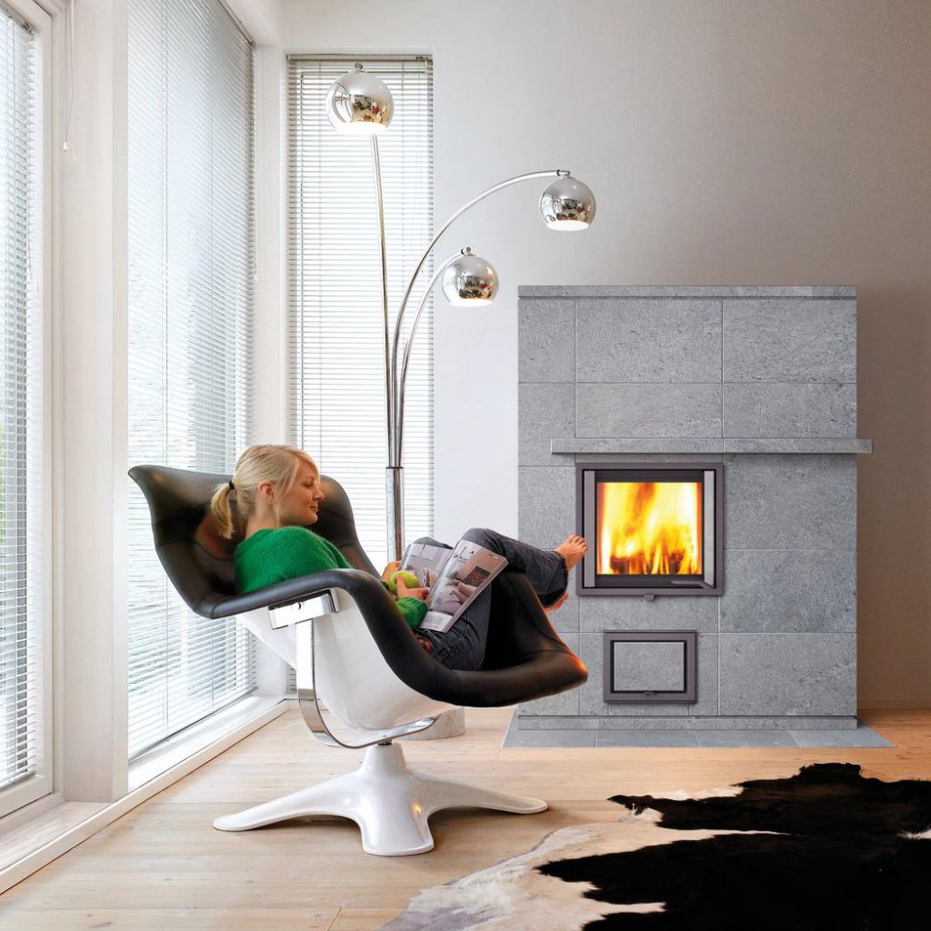 A woman enjoys the warmth of the fire in the living room